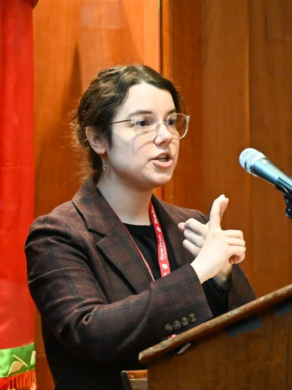 Katie conner delivers an academic talk at from a podium