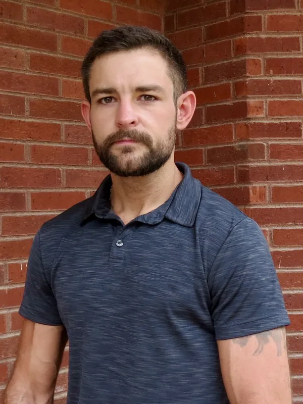 Headshot of Kyler; navy polo shirt 